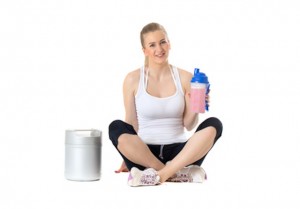 Young sporty woman sitting with protein shake