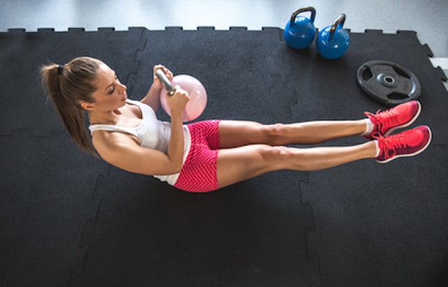 Woman working on her abs with kettlebell