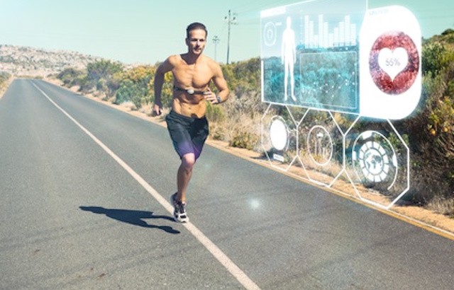 Athletic man jogging on open road with monitor